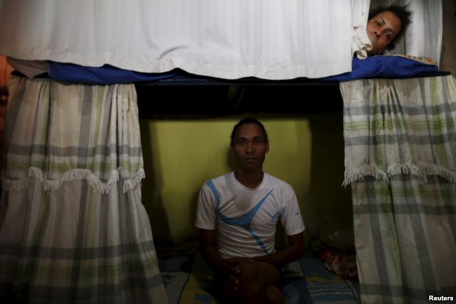 Inmate Alvis Javier (L), poses for a photograph as another prisoner looks from his bunk inside the transgender gallery in La Joya prison on the outskirts of Panama City, Panama