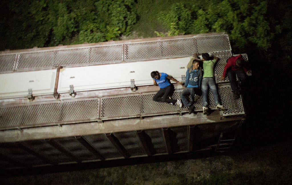 a trial of impunity: thousands of migrants in transit face abuses amid mexico's crackdown. In this Aug. 26, 2014 photo, Central American migrants rest atop the last boxcar of a moving freight train as it heads north from Arriaga toward Chahuites, Mexico. A Mexican crackdown seems to be keeping women and children off the deadly train, known as "The Beast," that has traditionally helped thousands of migrants head north. The once-open route to the United States has become so difficult that trains now carry a small fraction of the migrants they used to, and almost exclusively adult men. (AP Photo/Rebecca Blackwell)
